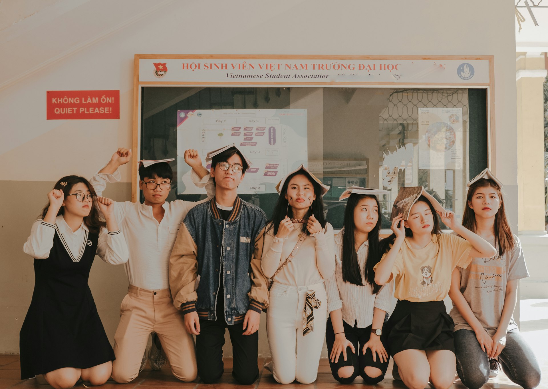 seven persons kneeling near wall during daytime